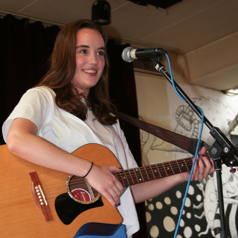 Antje Terpsma met een gitaar op het podium