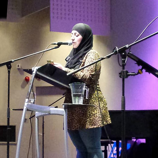 Badia Et-Talabi achter een microfoon