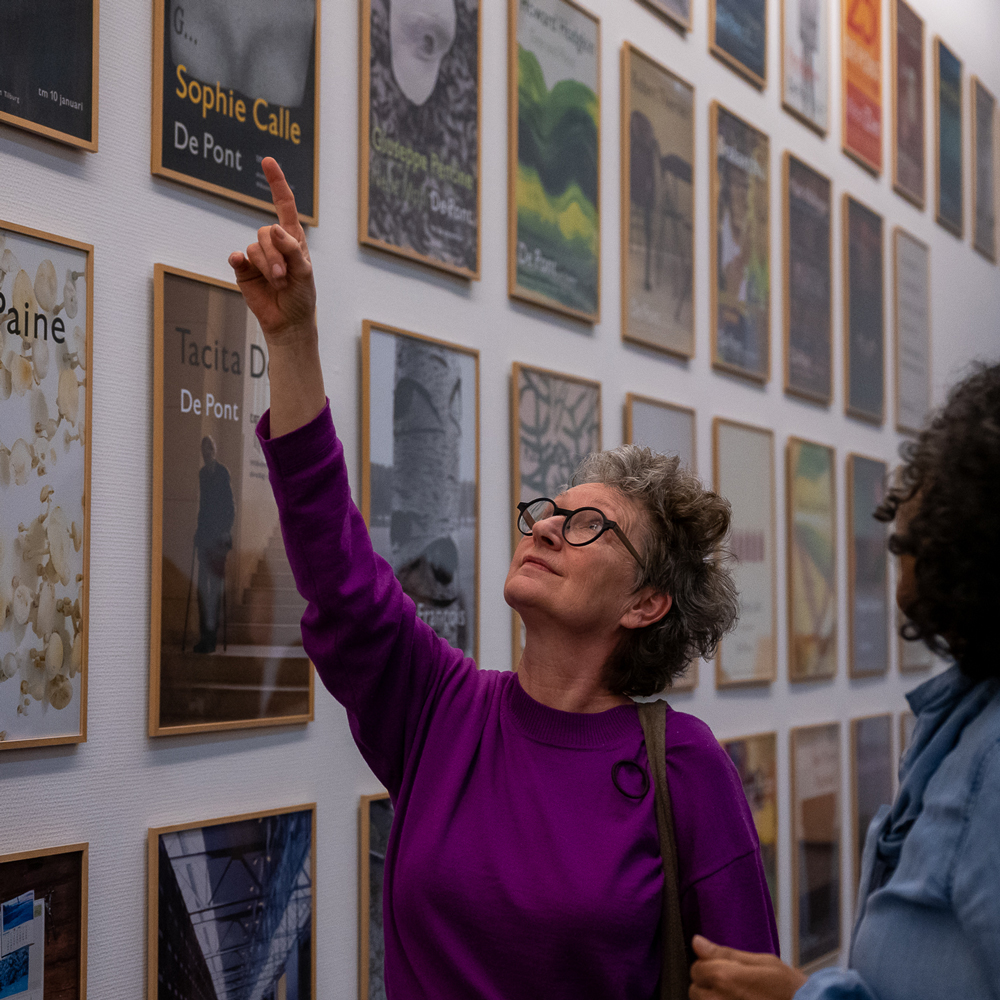 Marie José Eijkemans wijst naar een poster
