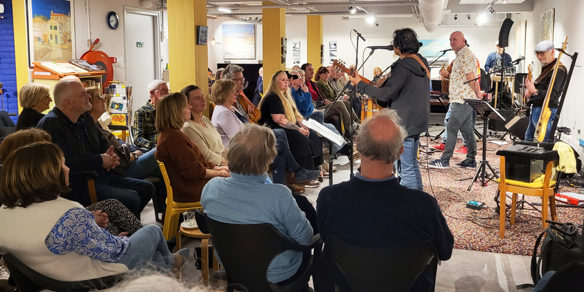 Optreden van Muziekgroep Vrolijk in Het Gele Huis voor een zittend publiek