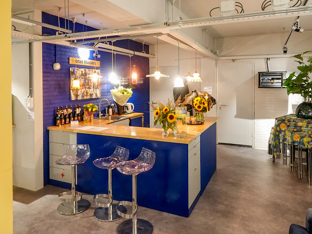 een gezellige bar met barkrukken en vazen met zonnebloemen