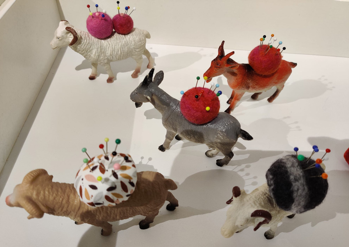 Diverse beesten als schapen, ezels met een speldenkussen op hun rug