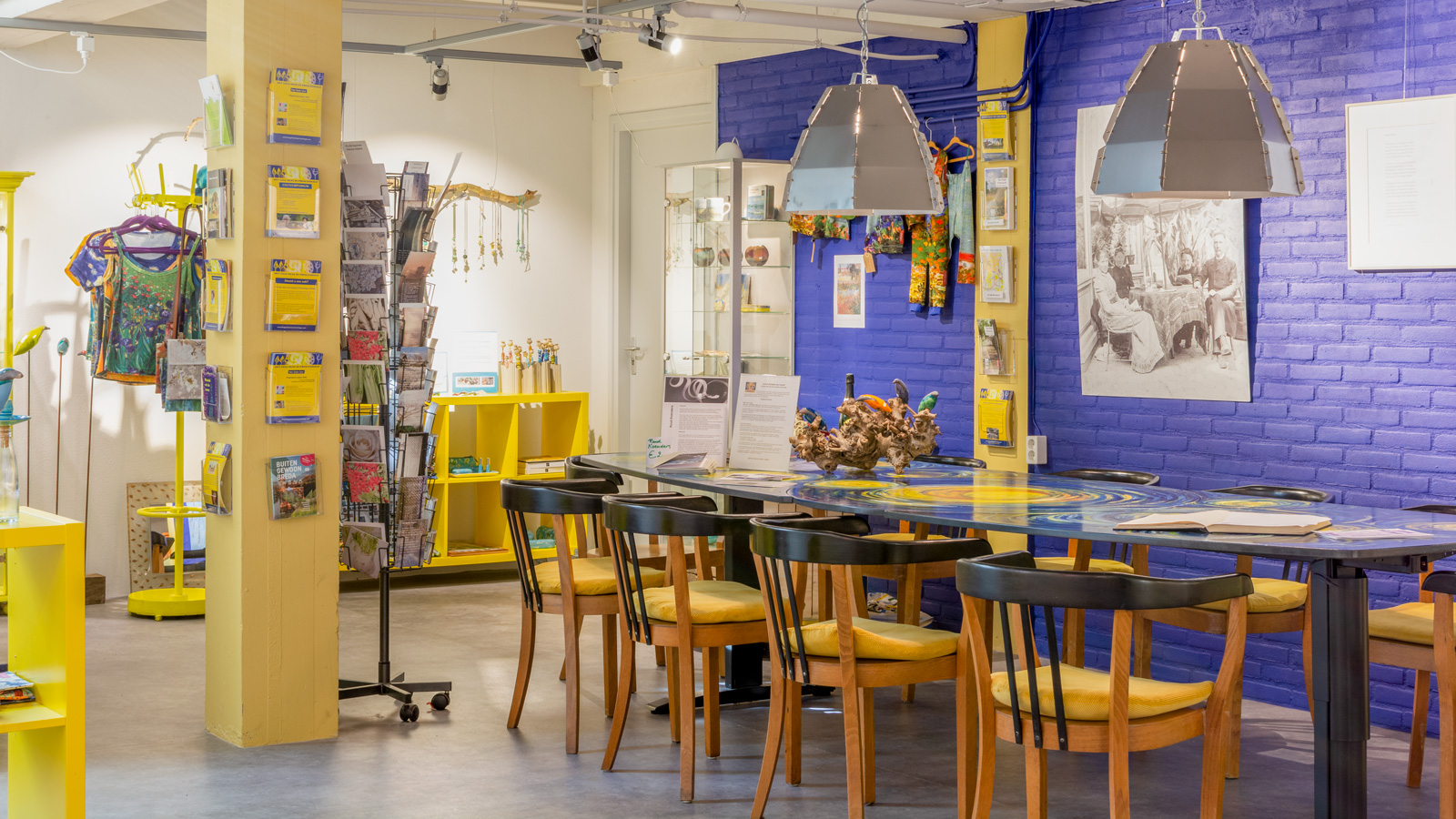 Geel-blauwe winkelruimte met tafel en stoelen
