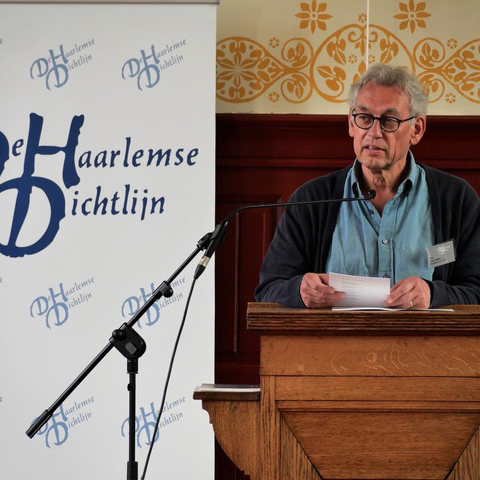 Frans Terken achter een spreekstoel met een banner De Haarlemse Dichtlijn
