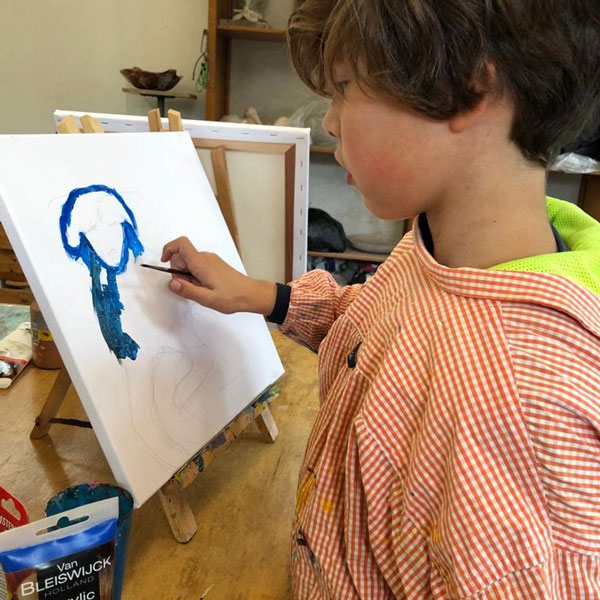 Kind schildert een hond tijdens kinderkunstklas