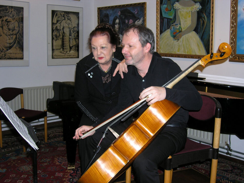 pianiste Marie-Louise Schwab-van Doornum en cellist Tomáš Nývlt met een cello in een kamer met schilderijen.
