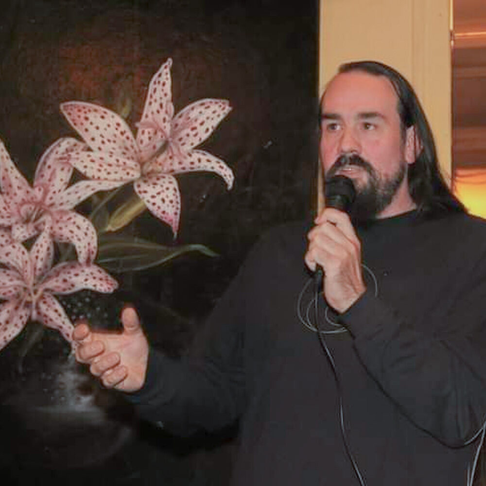 Gerardo Insua Teijeiro naast een schilderij met bloemen