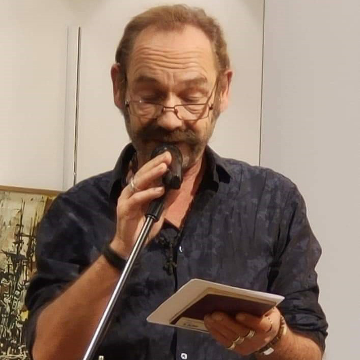 bob kalkman spreekt met een microfoon en boek in zijn handen