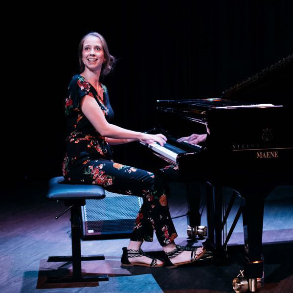 vrouw speelt piano op een podium