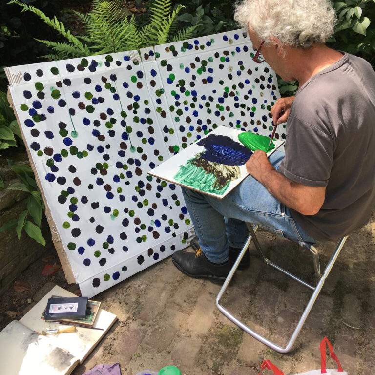 schilder plaatst stippen op een bord karton