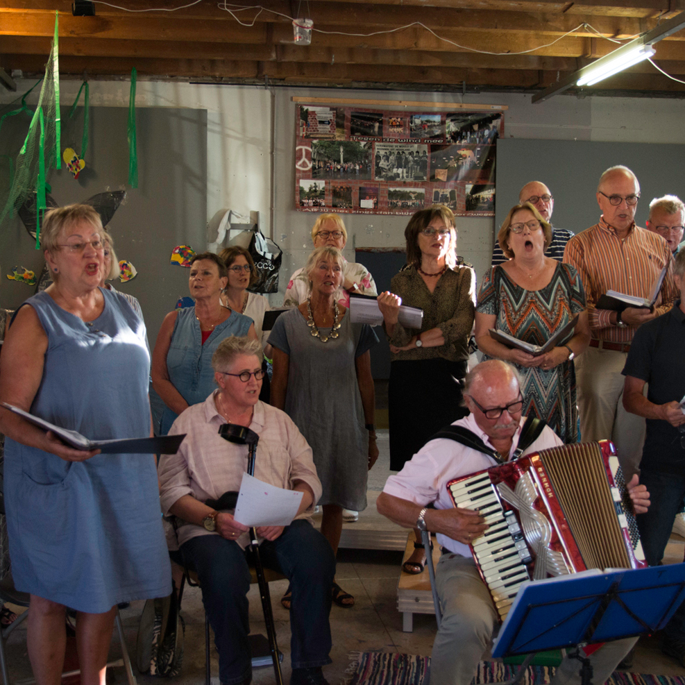 Actiekoor 'Tegen de Wind mee' zingt tijdens een optreden