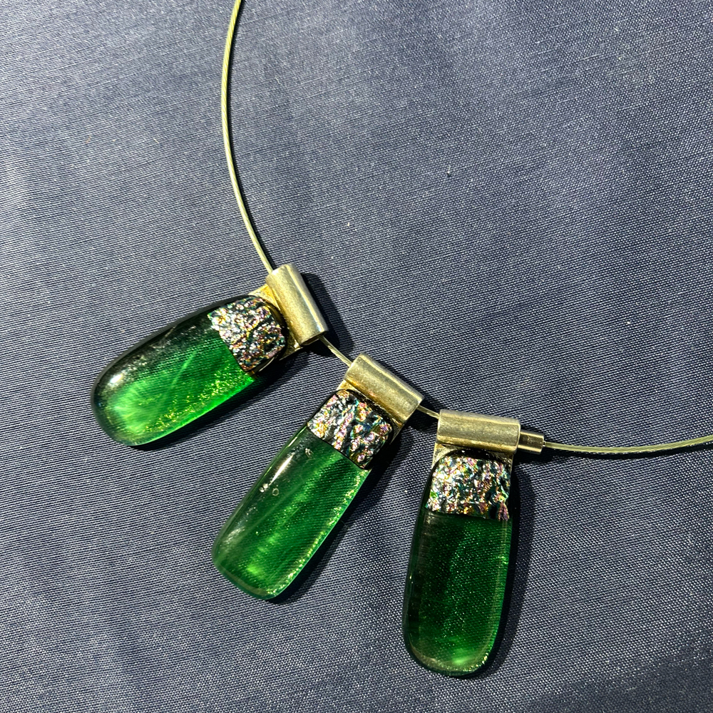 Drie groene, rechthoekige met afgeronde hoeken, glazen hangers voor aan een ketting