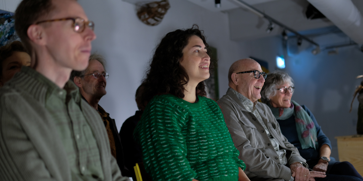 Voorstellingen beoeken in Het Gele Huis: een gevarieerd publiek bekijkt een cabaretvoorstelling
