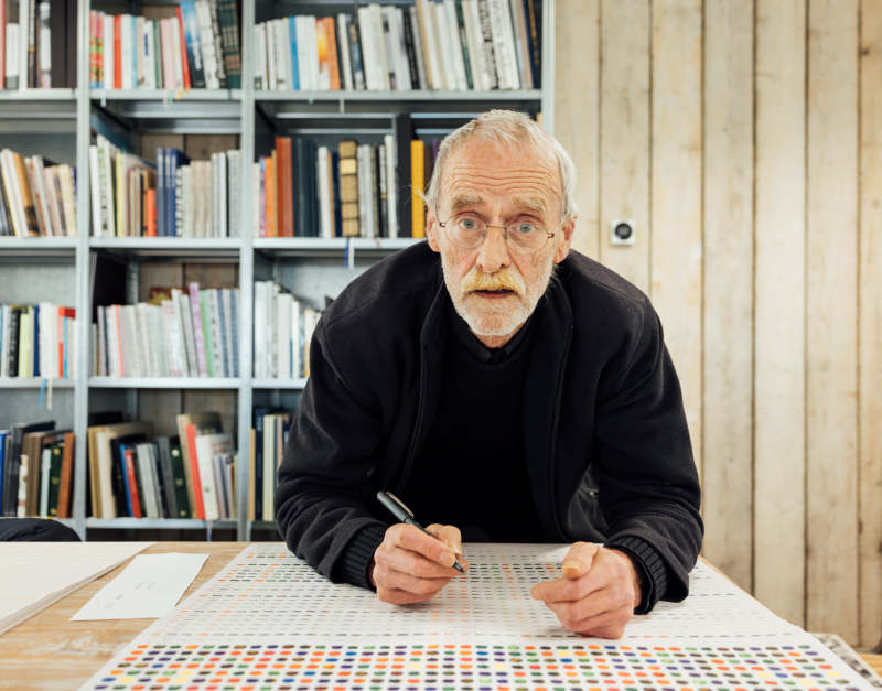 Grafisch kunstenaar Henk Cornelissen achter een tekentafel