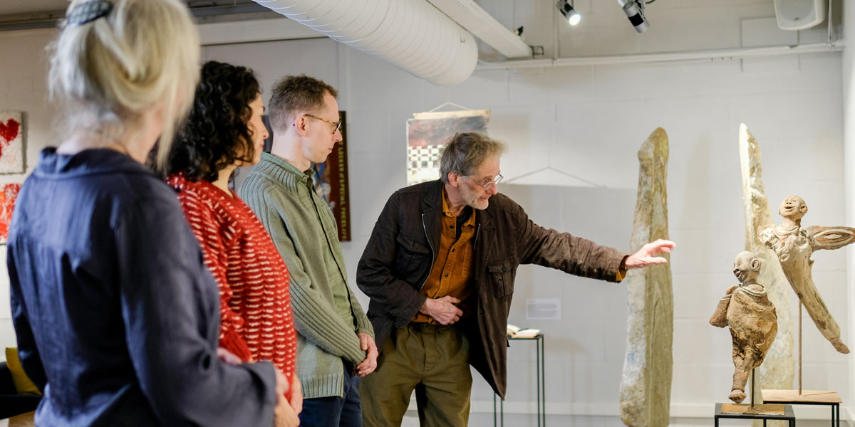 bezoeker bekijkt een expositie in Het Gele Huis en vertelt wat hij ziet