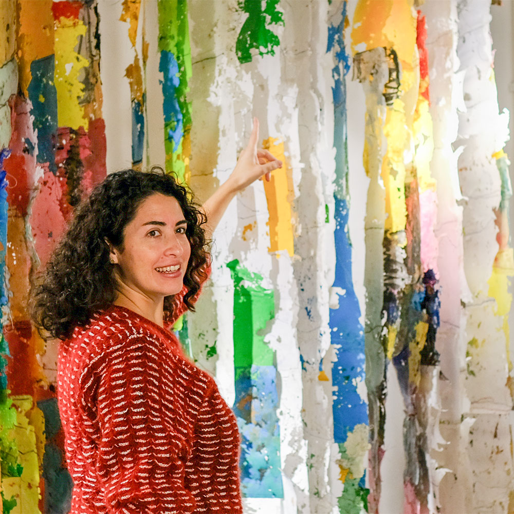 vrouw wijst naar de verschillende kleuren van een 3d kunstwerk